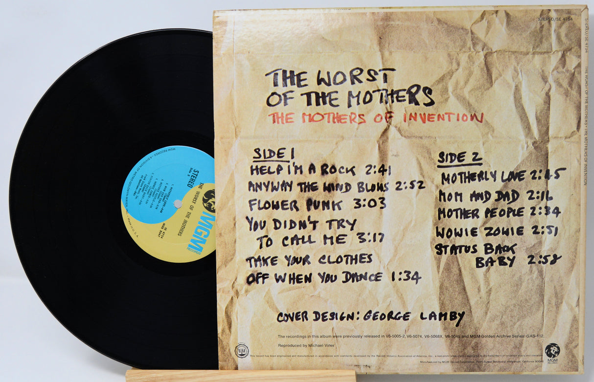 Vinyl record album cover for The Worst of the Mothers, showing the black record partially pulled from the beige paper sleeve with printed track listings and a blue/gold center label.