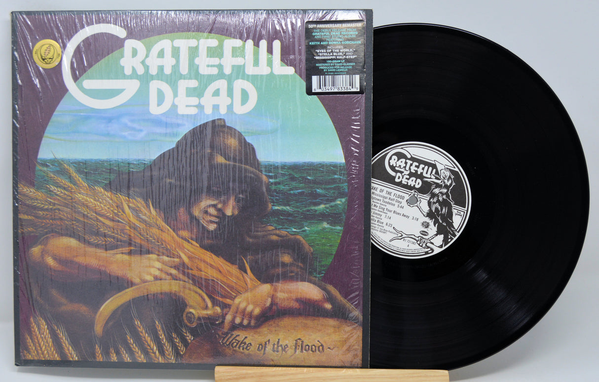 Vinyl record and cover of 'Grateful Dead' album 'Wise One of the Flood' on a light gray background