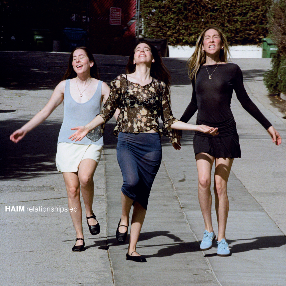 Three women walking together on a sidewalk with 'HAIM relationships ep' text overlay.