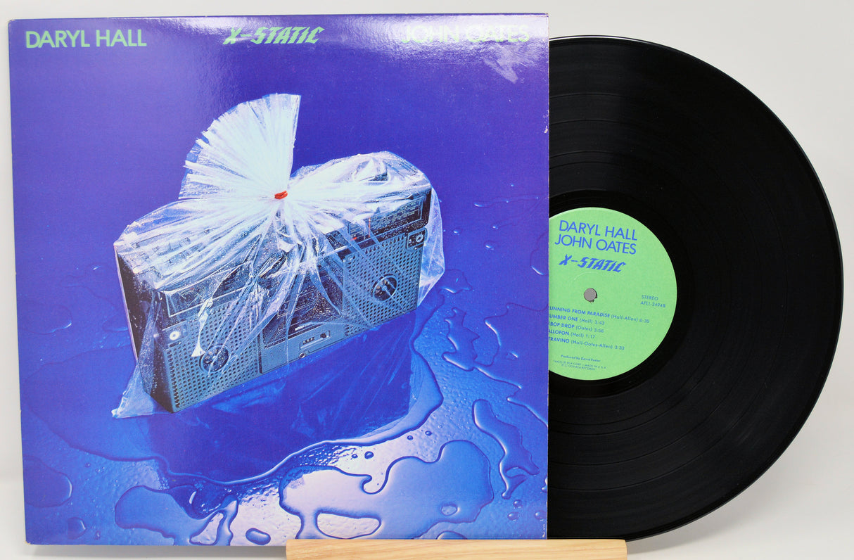 Vinyl record with a blue front cover featuring a boom box and 'Daryl Hall & John Oates' X-Static text.