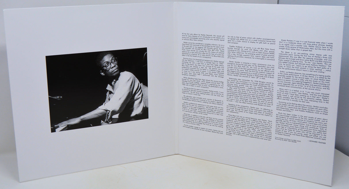 Open book with a black and white photo on one side and text on the other, on a white background.