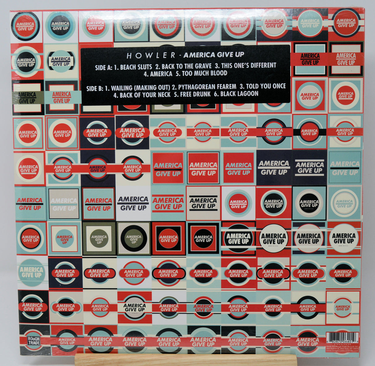 Vinyl record cover with 'America Give Up' by Howler, featuring a pattern of the album title.