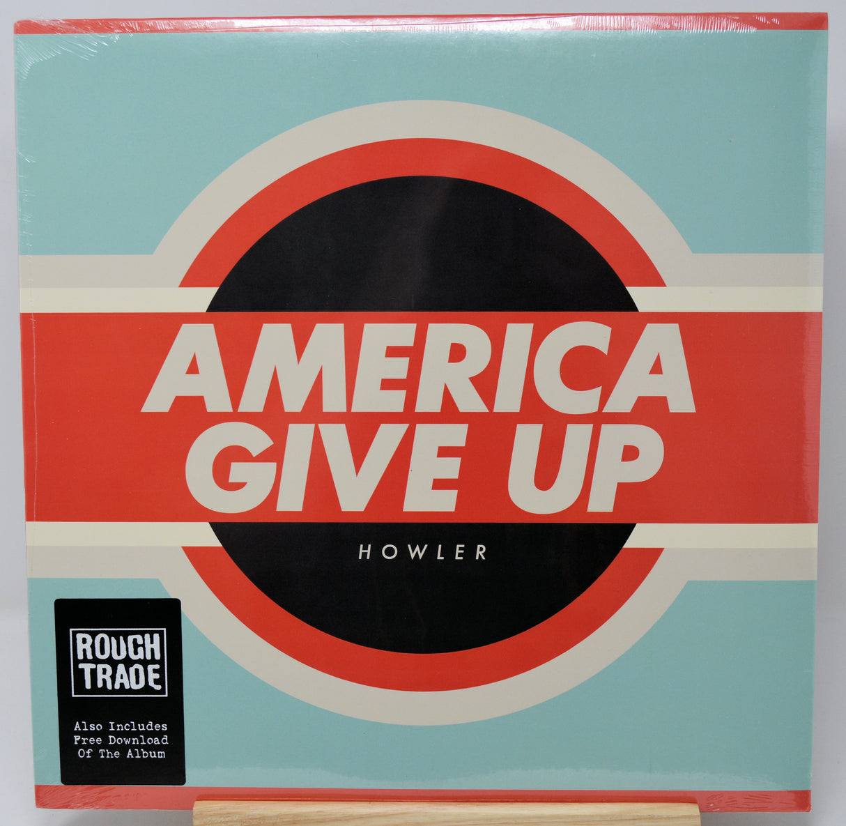 Vinyl record cover for 'America Give Up' by Howler with a red and blue design.