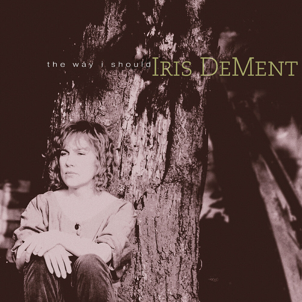 Album cover with a person sitting against a tree, featuring text 'the way i should' and 'Iris Dement'.