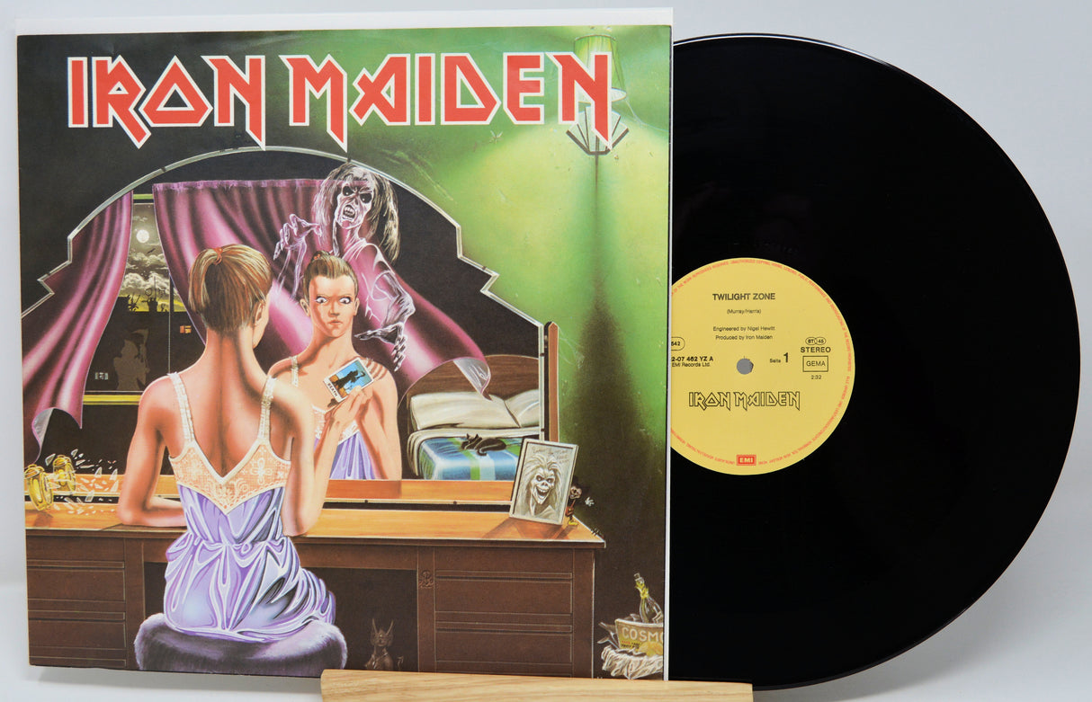 Vinyl record with Iron Maiden album cover showing a woman in a purple dress looking into a mirror.