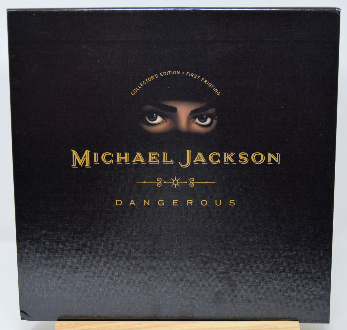 Black album cover with 'Michael Jackson Dangerous' and a face peeking over the top.