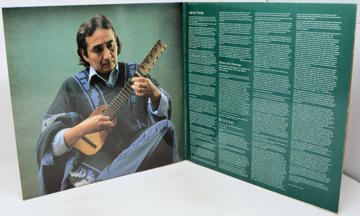 Album cover with a person playing guitar on one side and text on the other, on a white surface.