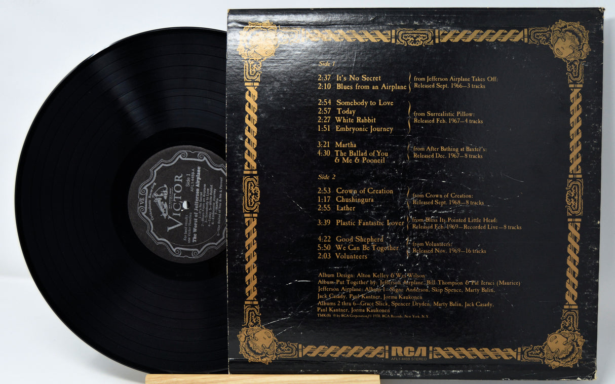 Vinyl record with gold and black cover displaying tracklist on a white background