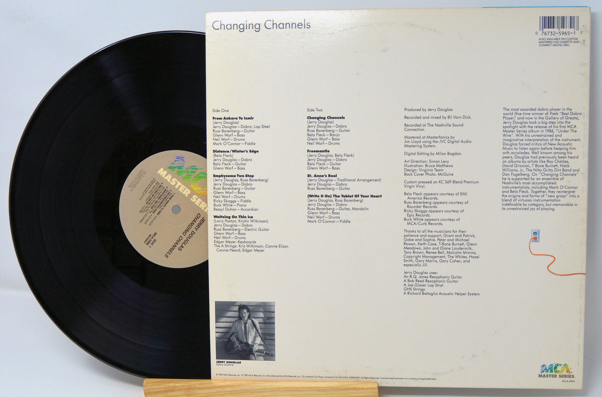 Vinyl record with cover displaying tracklist and album art on a light gray background