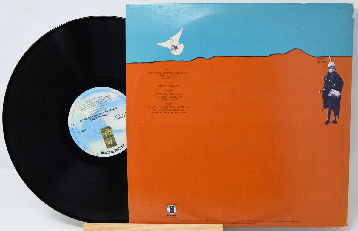 A vinyl record partially pulled from its sleeve, showing the black record and the back cover artwork. The sleeve has a bright orange lower half, a light blue upper band, a white dove illustration, and a small standing figure on the right.