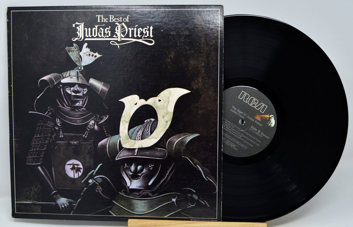 Vinyl record album 'The Best of Judas Priest' with the illustrated cover on the left and the black LP record partially pulled out on the right. The center label shows the RCA logo.