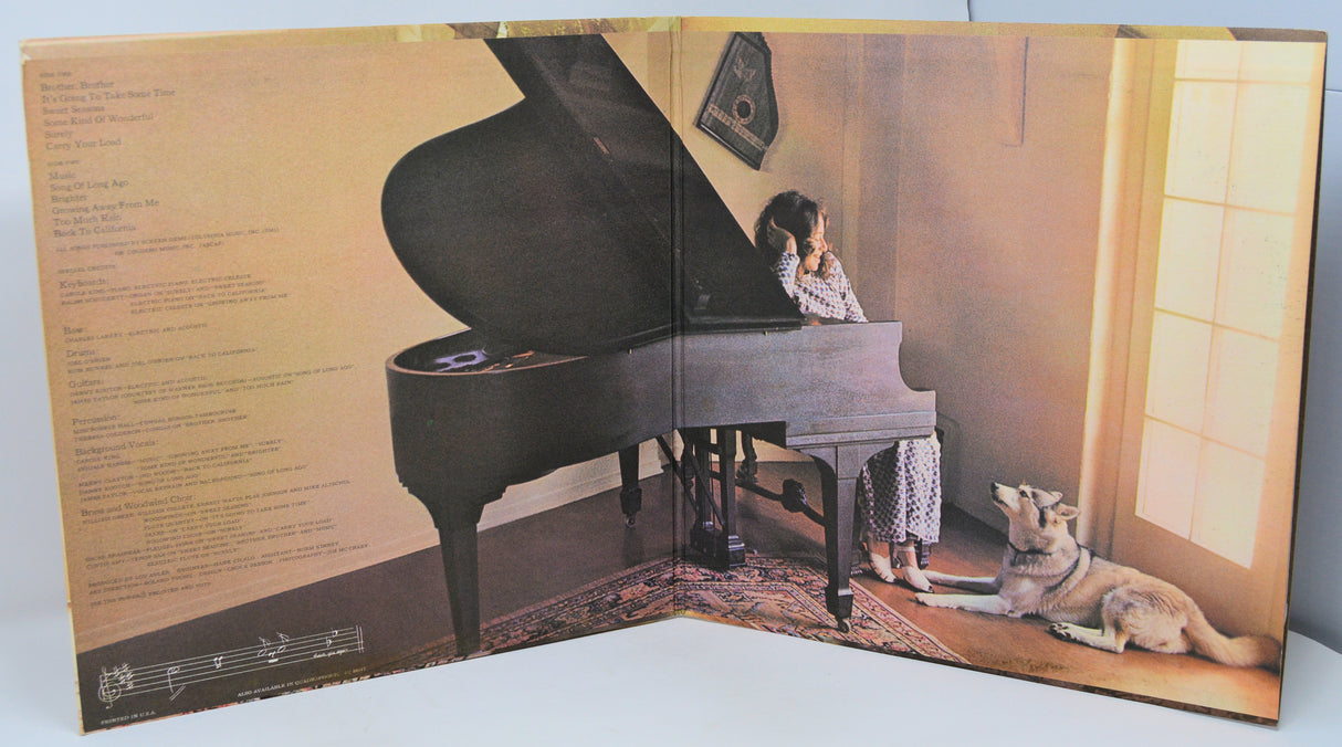 Album cover with a woman playing a piano and a cat sitting next to her.