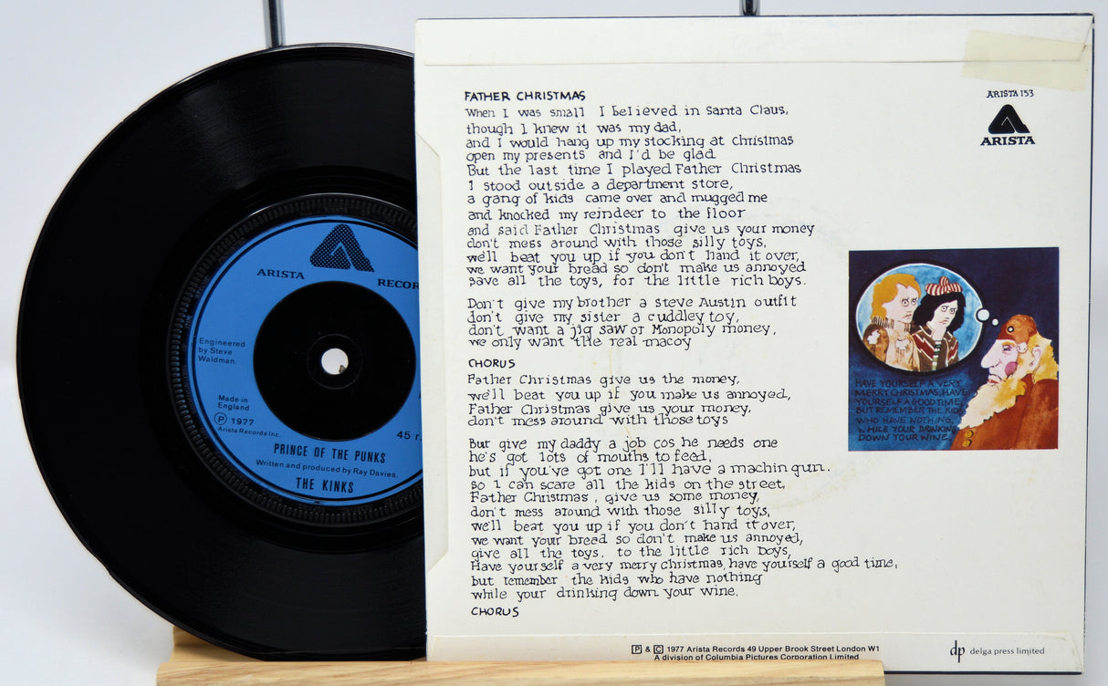 Vinyl record with a blue label and a lyric sheet on a white background