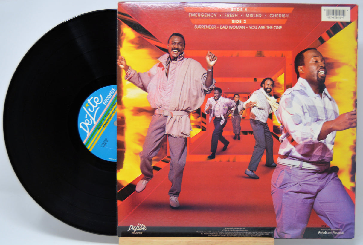 'Kool and The Gang Emergency' Vinyl record with a colorful cover featuring a group of people, including a prominent figure in a white shirt and purple pants.