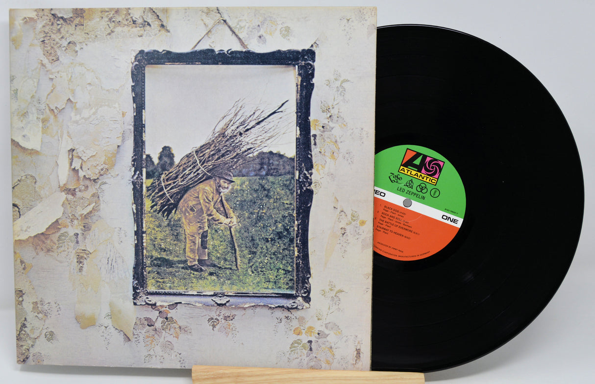 Vinyl record with a cover featuring an artistic design of a person carrying branches.