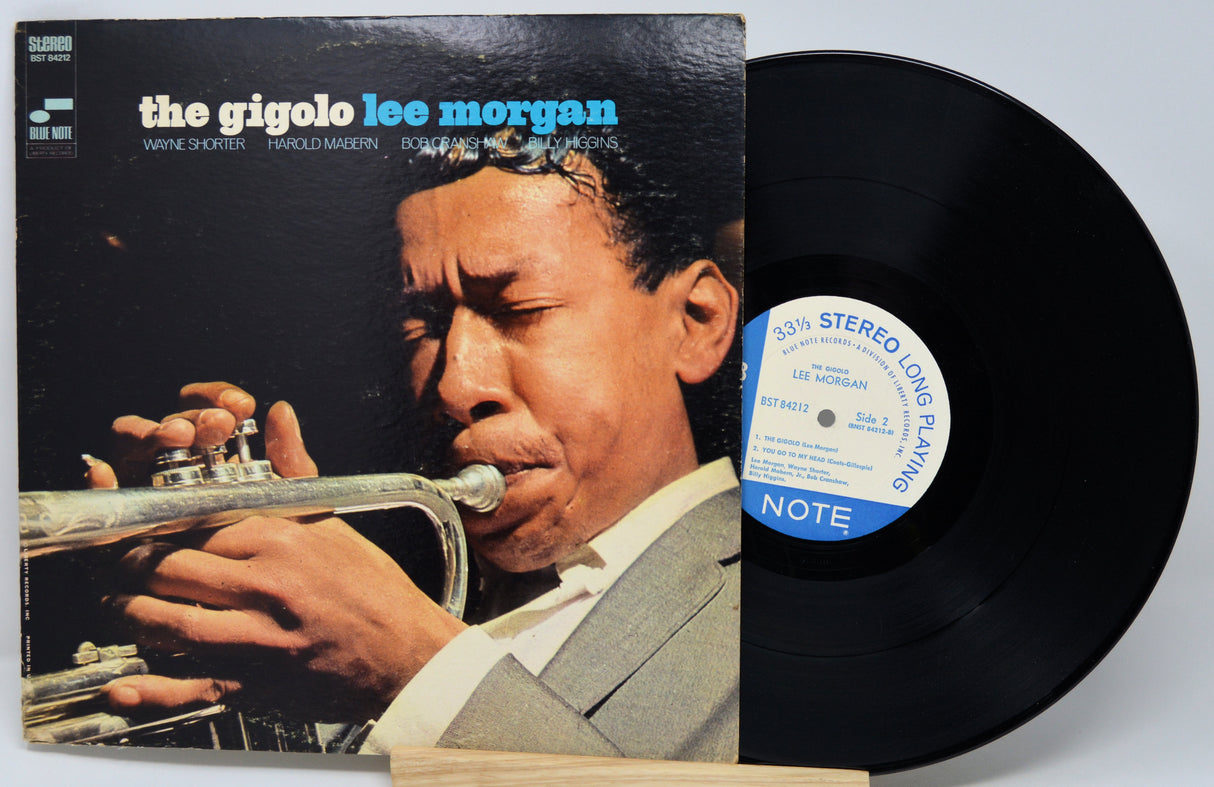 Vinyl record with cover featuring a musician playing a trumpet, on a light gray background.