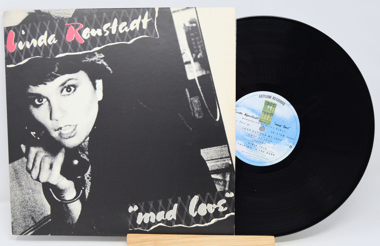 Vinyl record with cover featuring a black and white photo of a woman and text 'Linda Ronstadt Mad Love'.