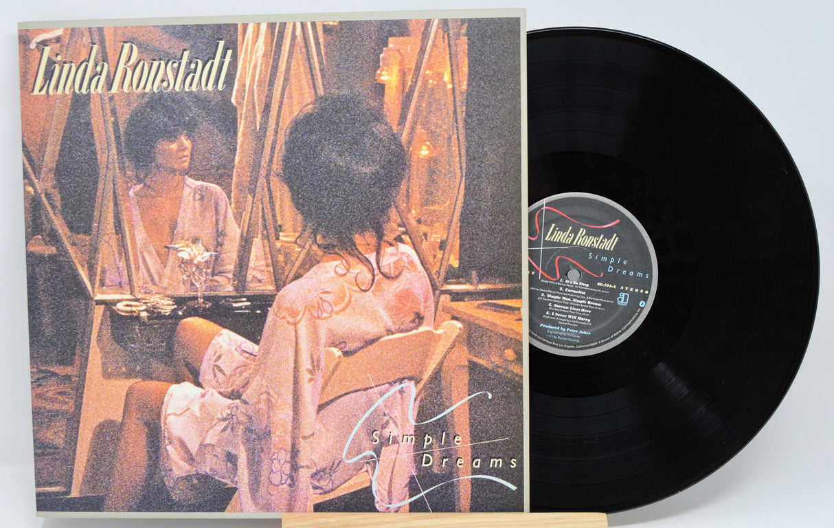 Vinyl record with cover featuring a woman sitting at a piano, titled 'Simple Dreams' by Linda Ronstadt.