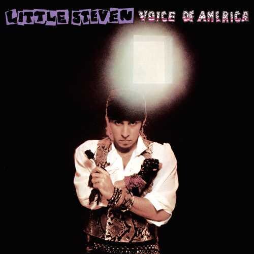 Little Steven holding a microphone and wearing a white shirt with a snake design, and a black vest, standing in a dark setting with 'Voice of America' text on the album cover.
