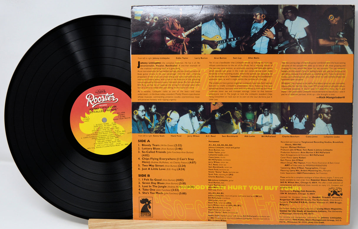 Vinyl record with orange label featuring band images and text on a white background