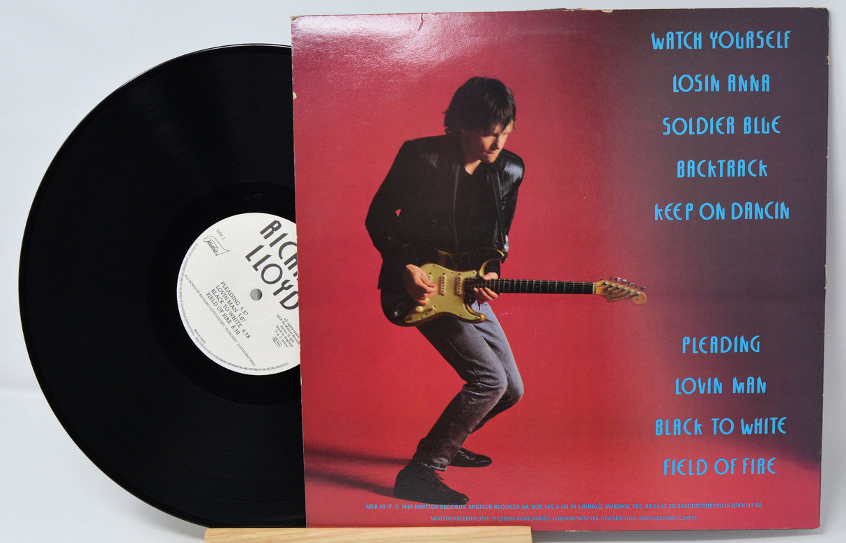 Vinyl record with a cover featuring a person playing guitar on a red background.