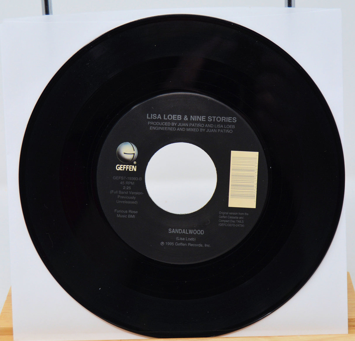 Black vinyl record with a white label on a white background