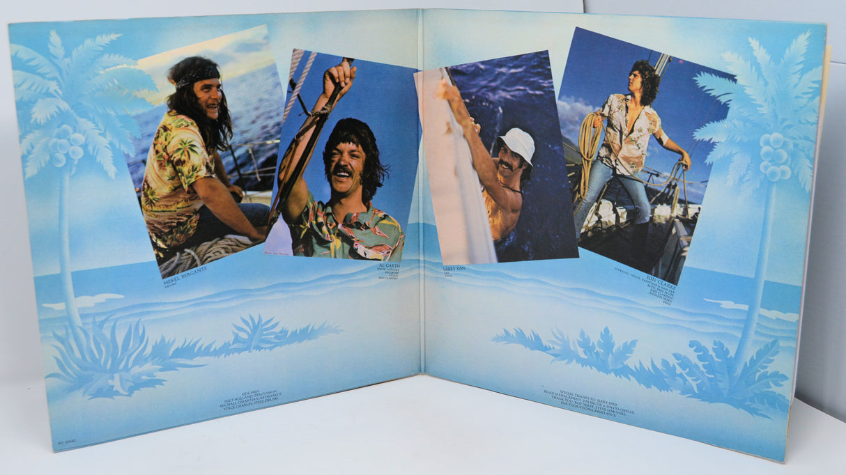 Inside gatefold album cover with four photos of a person on a boat against a blue background.