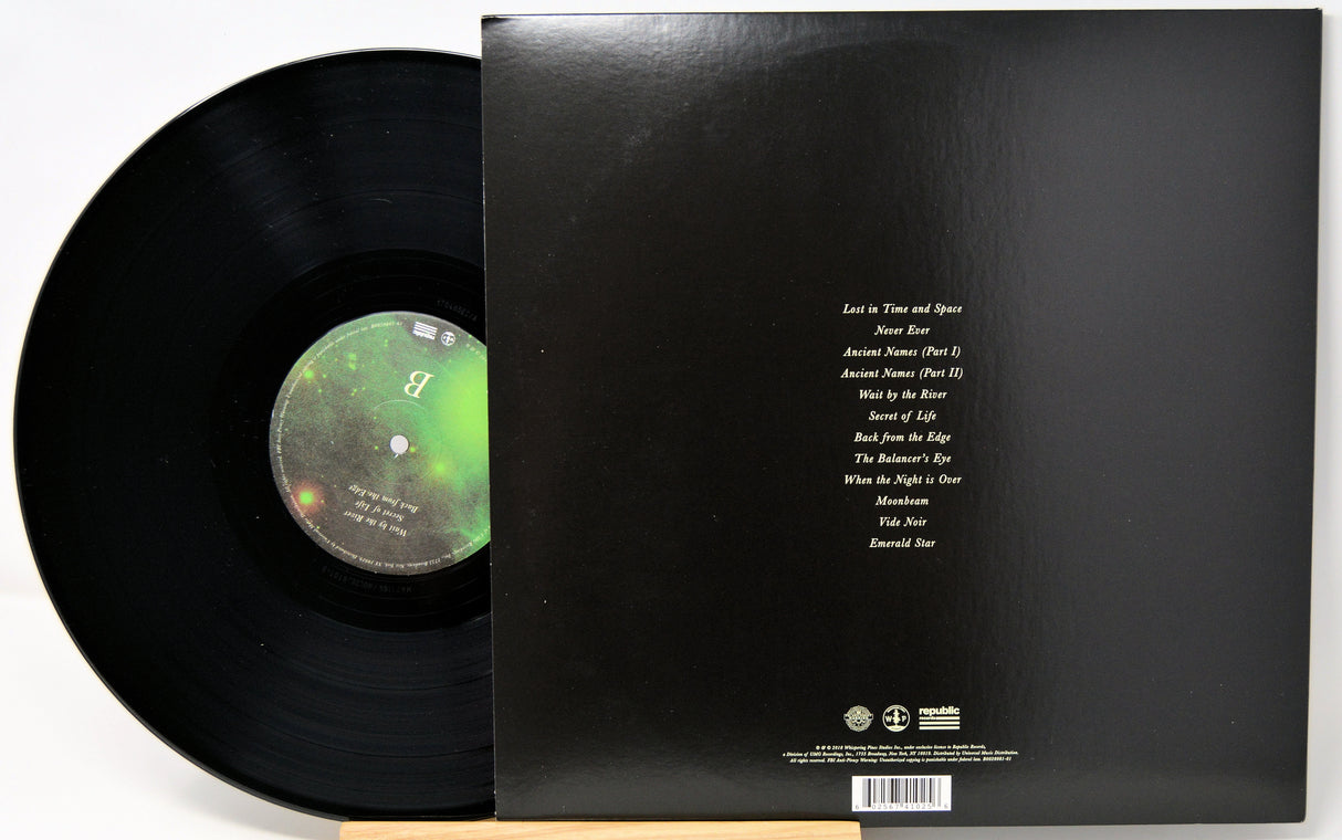 Vinyl record with green label and black cover displaying text