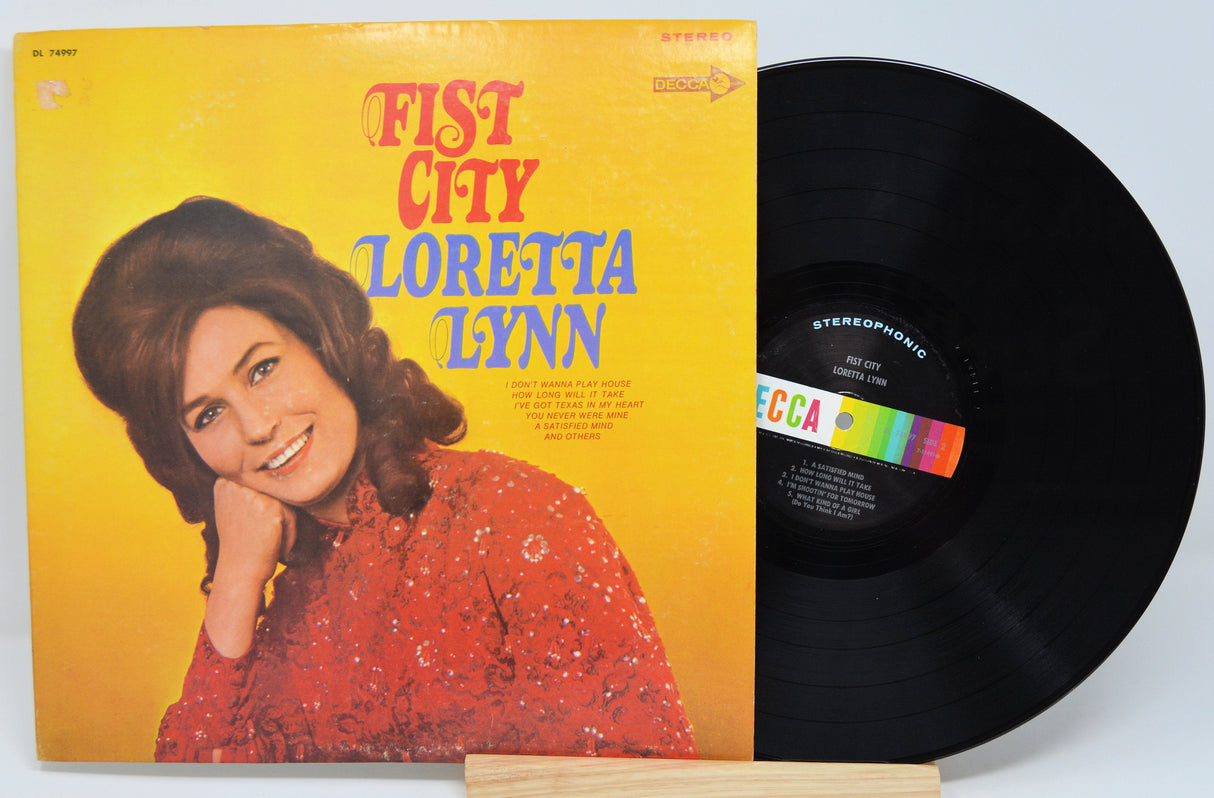 Front cover of Loretta Lynn Fist City vinyl record with portrait and vibrant yellow background