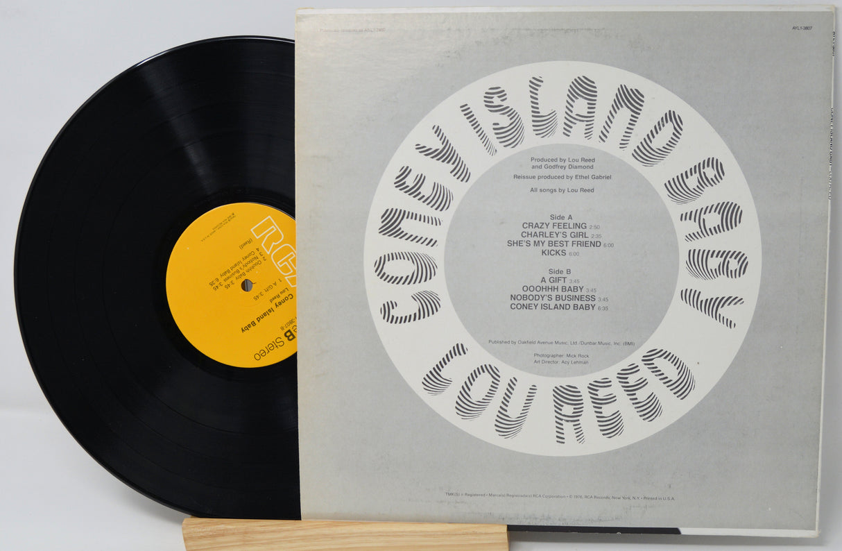 Vinyl record with a gray cover featuring text and a yellow label on a white background