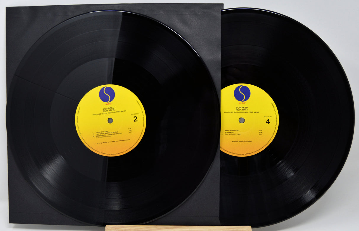 Two vinyl records with yellow labels on a white background
