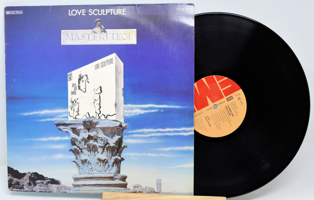 Vinyl record with cover featuring a sculpture and blue sky