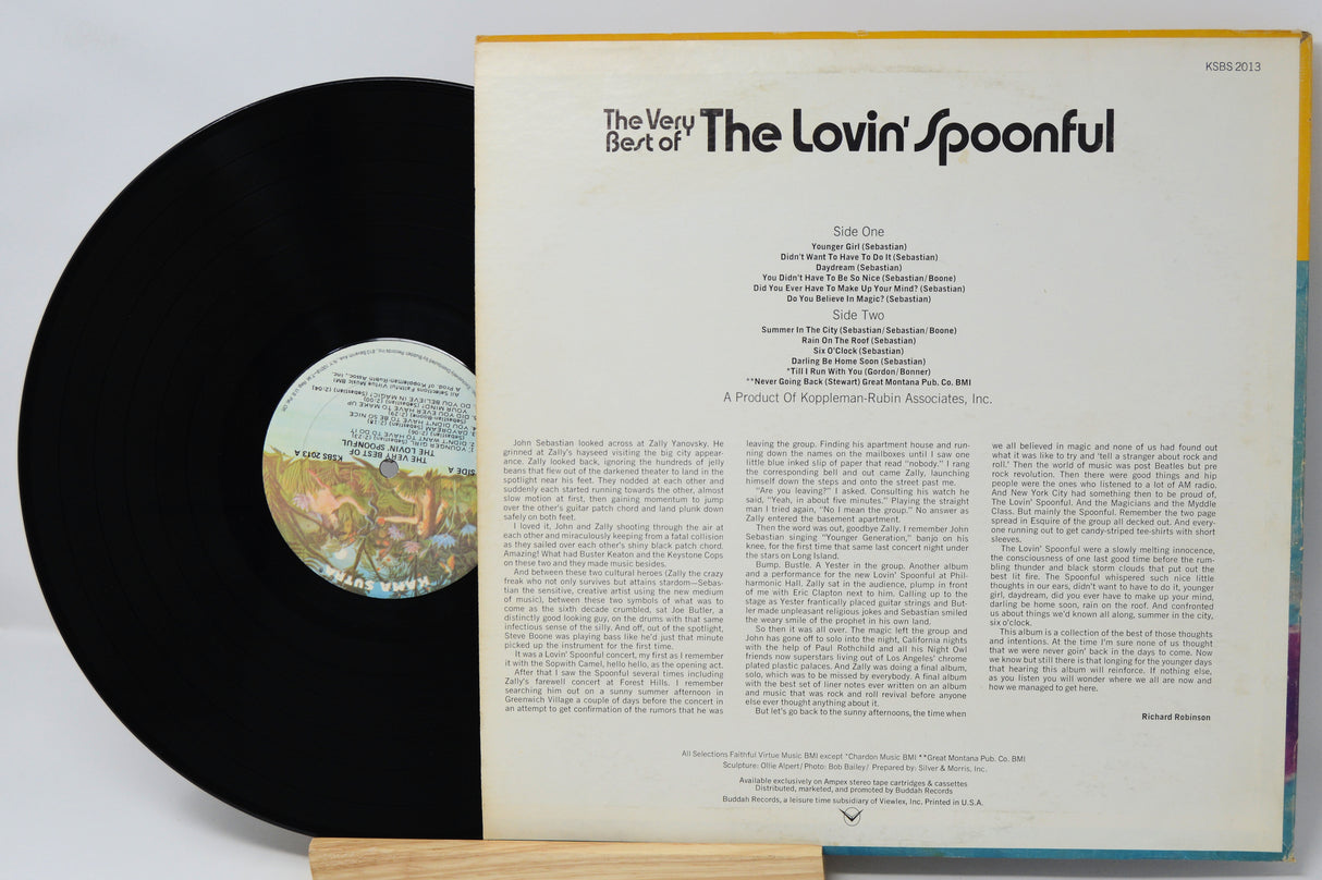 Vinyl record with cover displaying text and a small disc on a light gray background