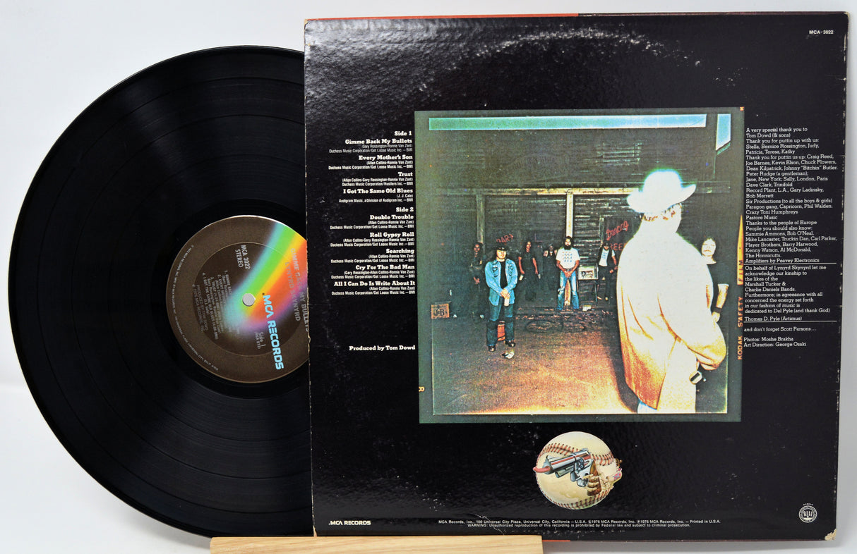 Vinyl record with cover featuring a band on stage and rainbow design