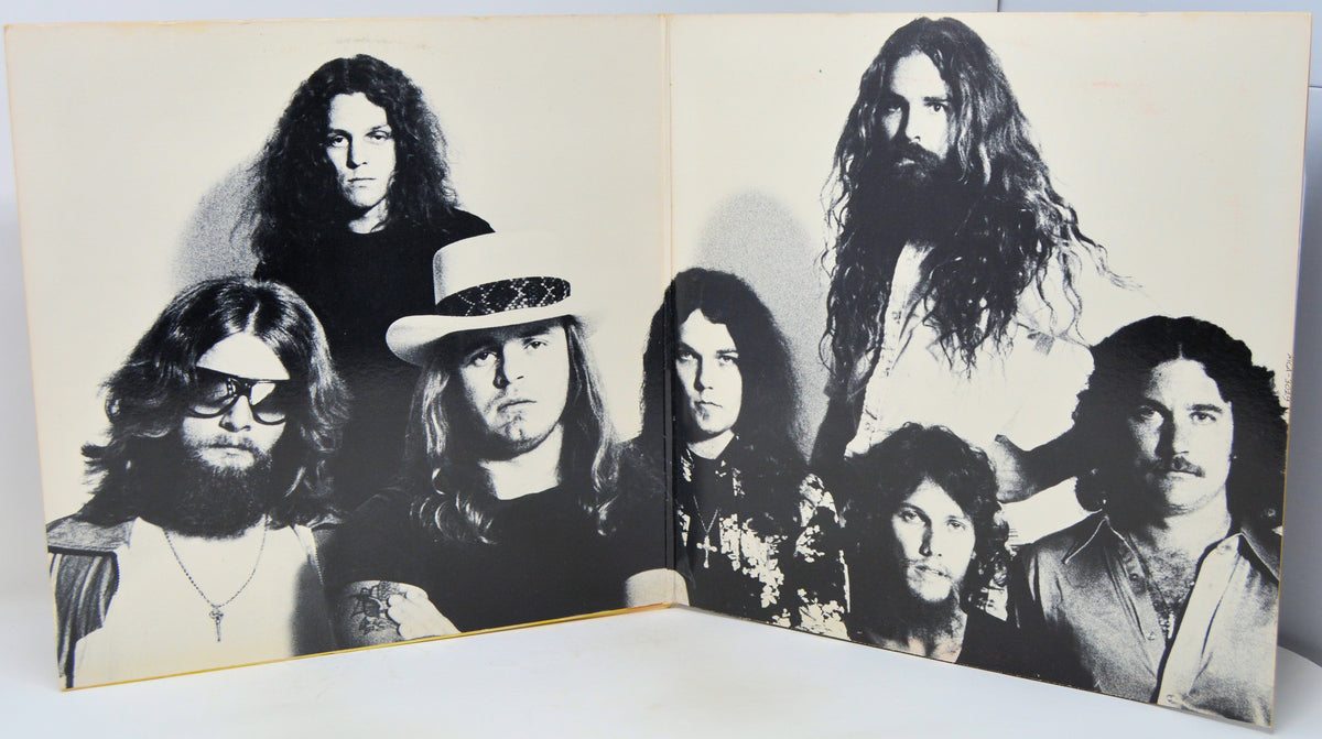 A vintage black and white printed photo print or poster showing a group of seven rock band members, displayed open against a white background.