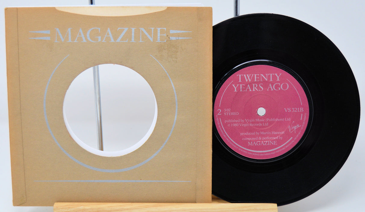 Vinyl record with a pink label and a magazine on a white background