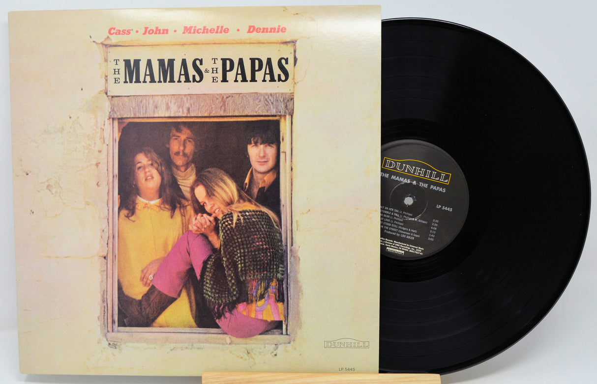 The Mamas and Papas vinyl record album shown with the front cover on the left and the black LP record partially pulled out on the right, photographed against a plain light background.