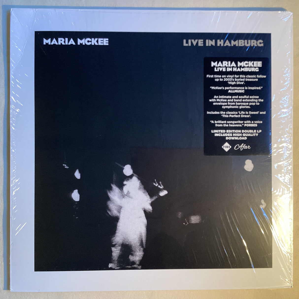Front cover of Maria McKee Live in Hamburg vinyl LP showing dark stage performance lighting