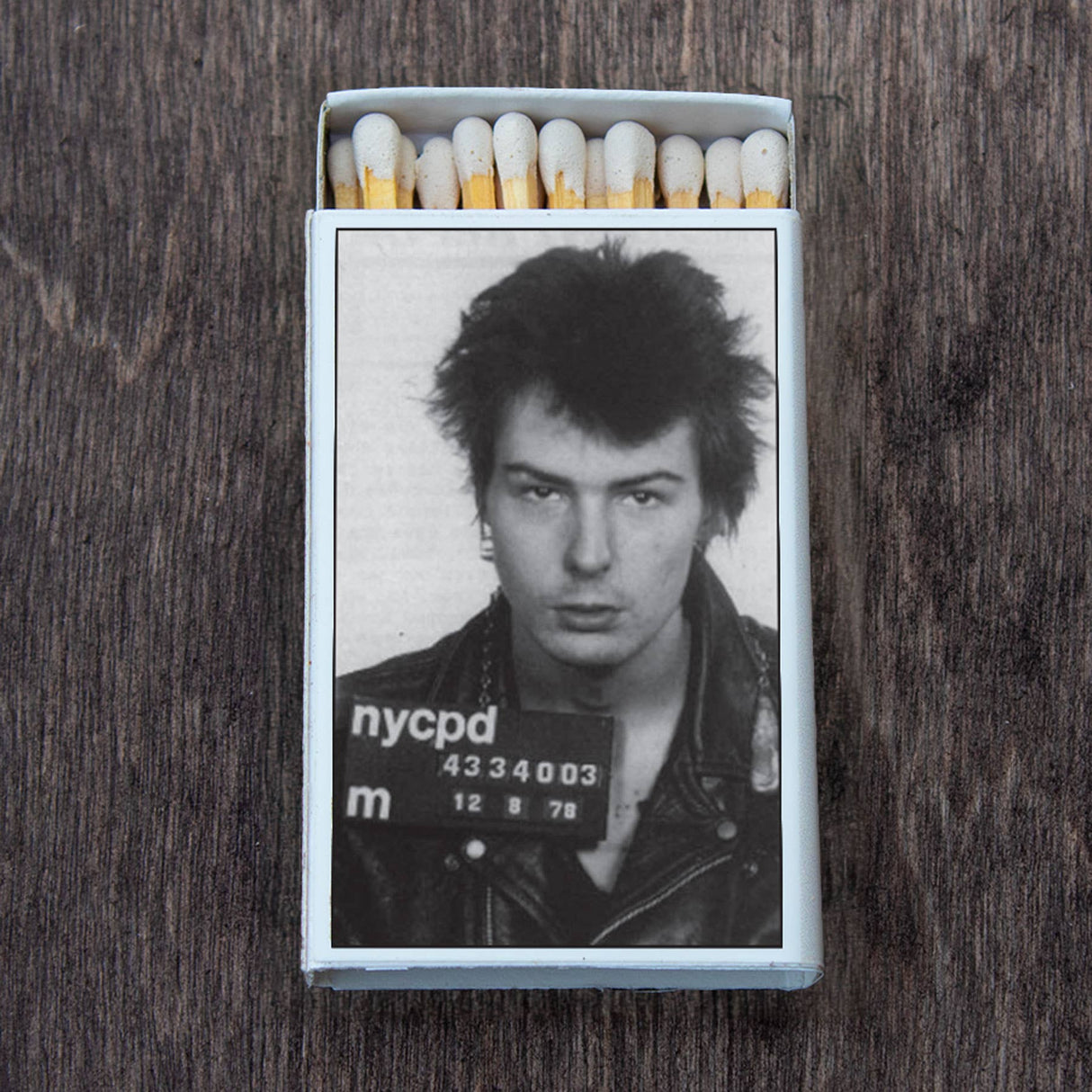 Matchbox with black and white photo of a punk rocker in leather jacket on wooden surface