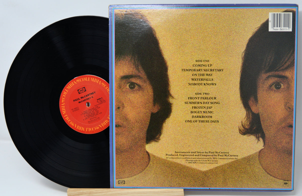 Vinyl record with a cover featuring a close-up of a person's face on a gold background.