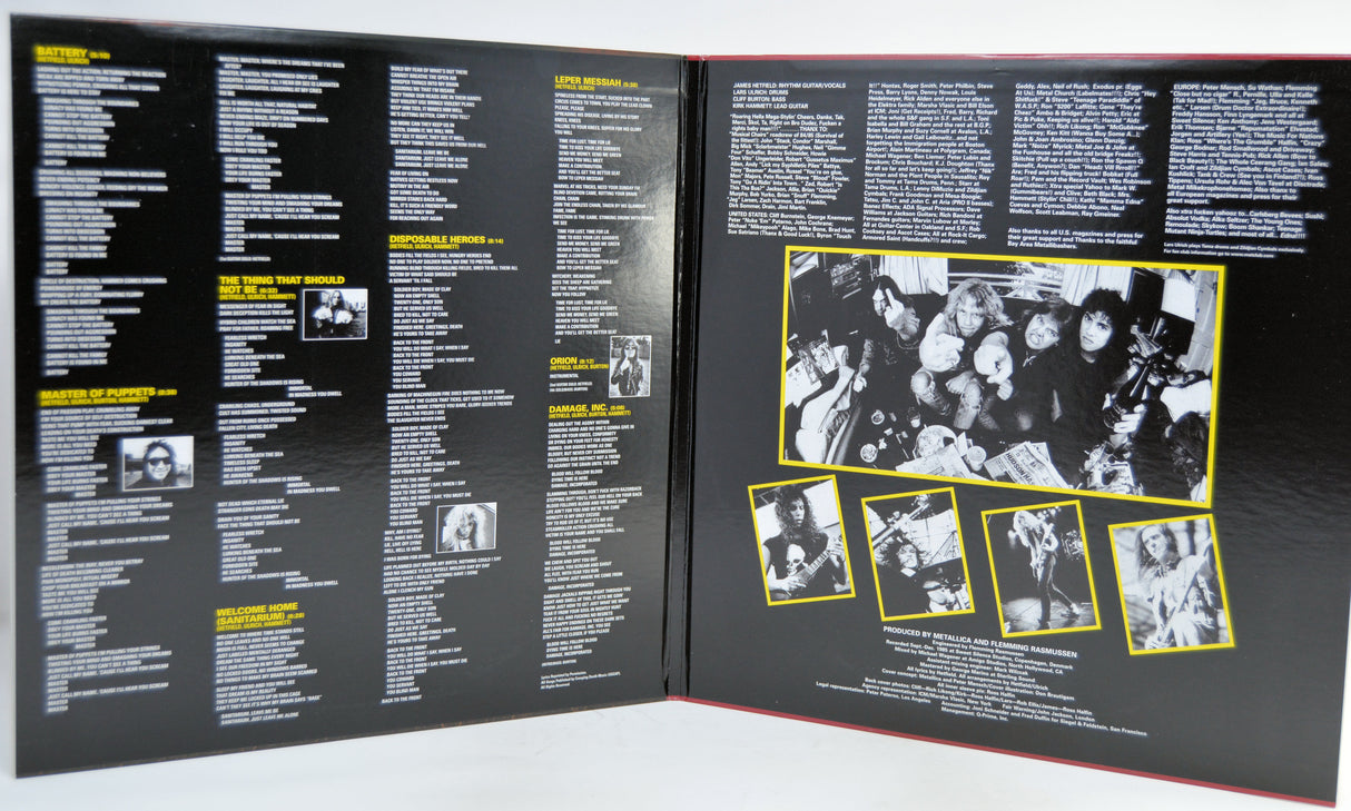 An gatefold cover with a black cover, showing printed text columns and several black-and-white photos outlined in yellow.