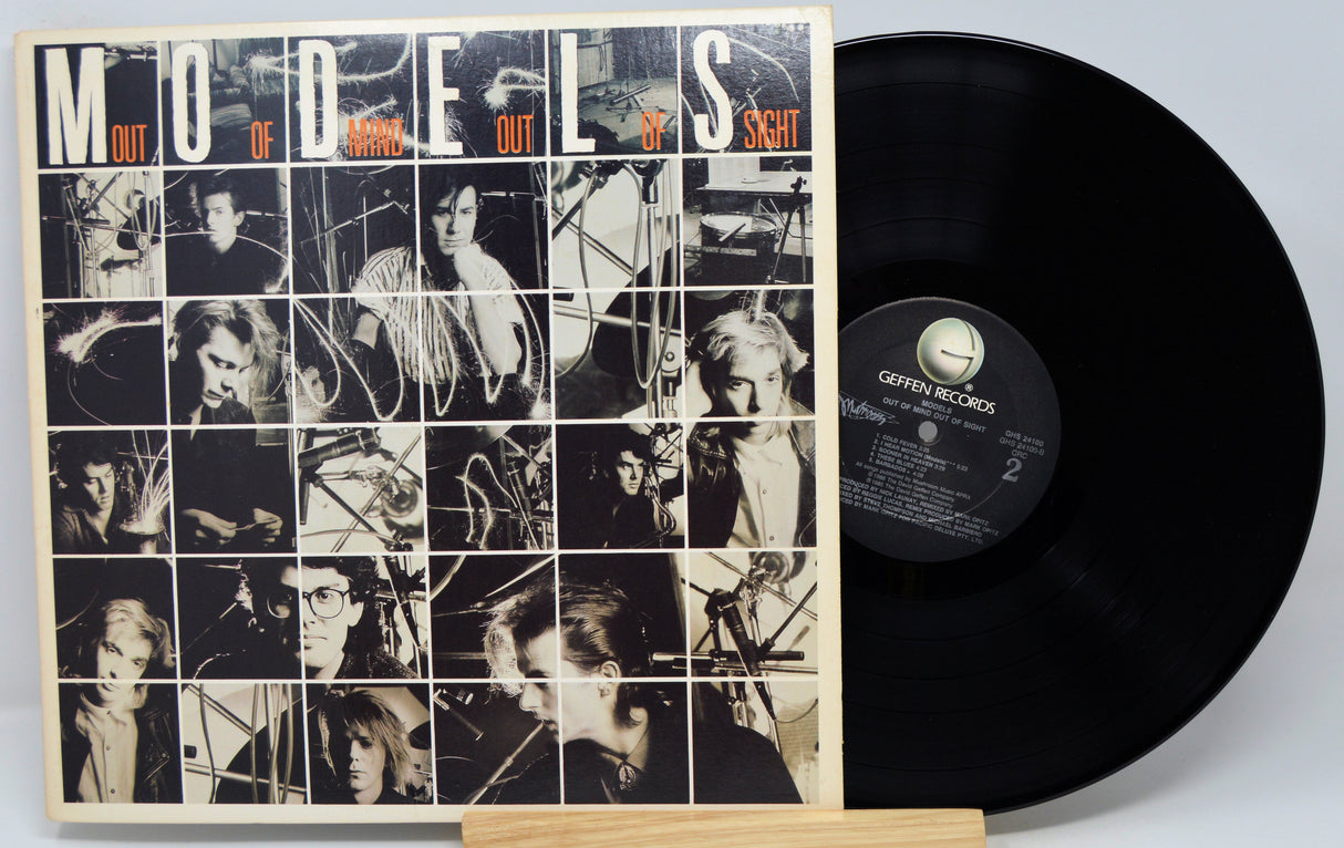 Vinyl record with cover featuring black and white images and text 'Models Out of Sight' on a light gray background.