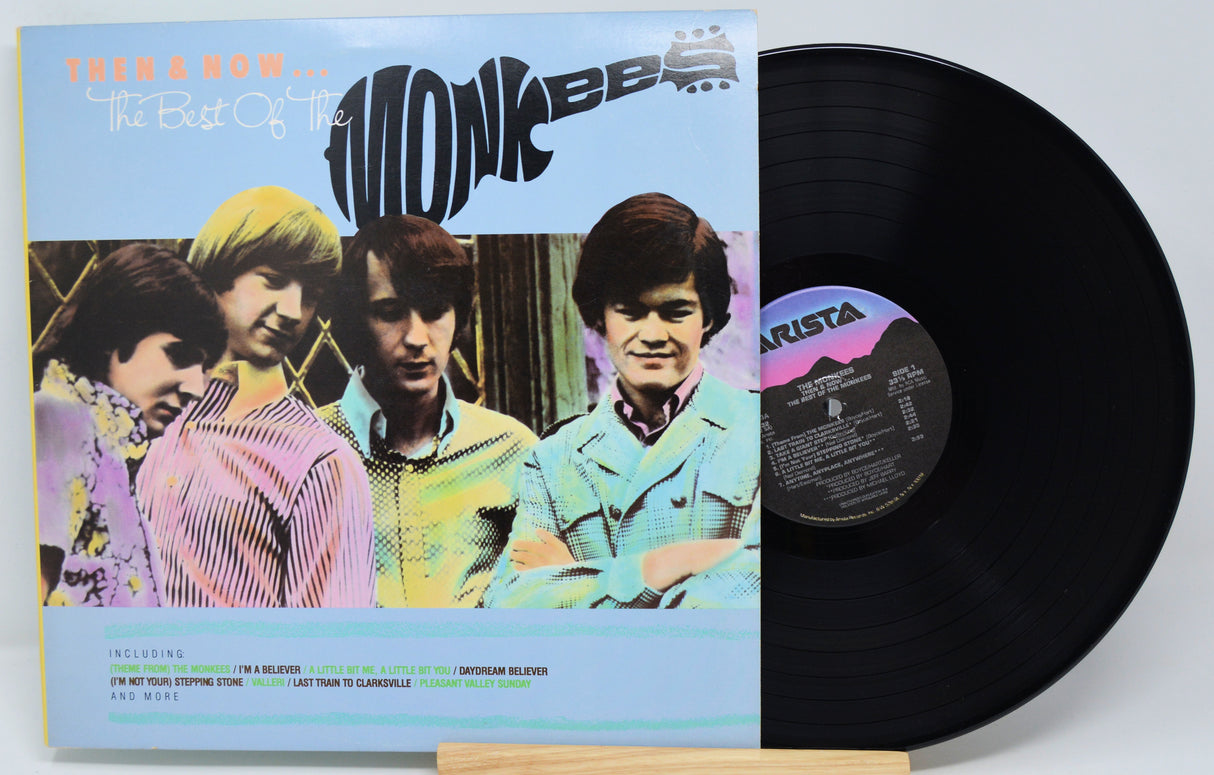 Vinyl record with cover featuring a band on a light gray background