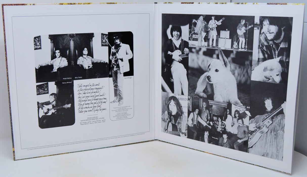 An open hardcover book or album spread showing black-and-white collage photographs and handwritten text pages, photographed against a plain light background.