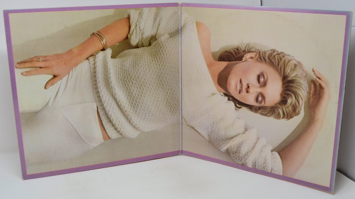 Open book showing a woman wearing a white knitted sweater on a plain background