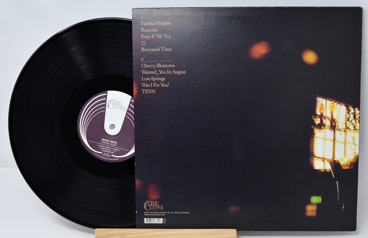 Vinyl record with cover featuring a blurred image of a building at night.