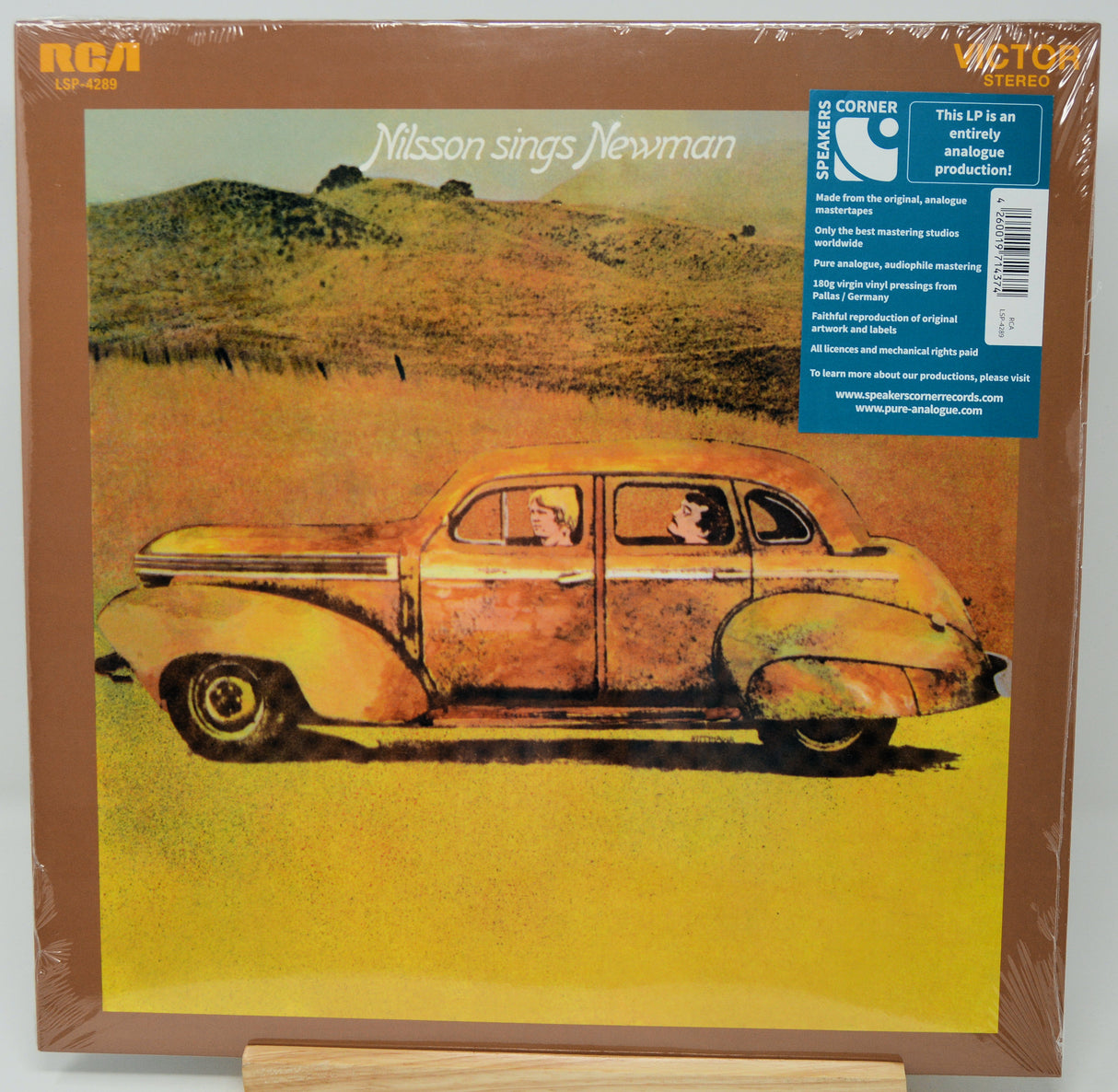 Misson Sings Newman LP album cover on a wooden surface, sealed in plastic wrap. The cover shows a vintage car in a yellow field with a blue Corner Records sticker on the right.