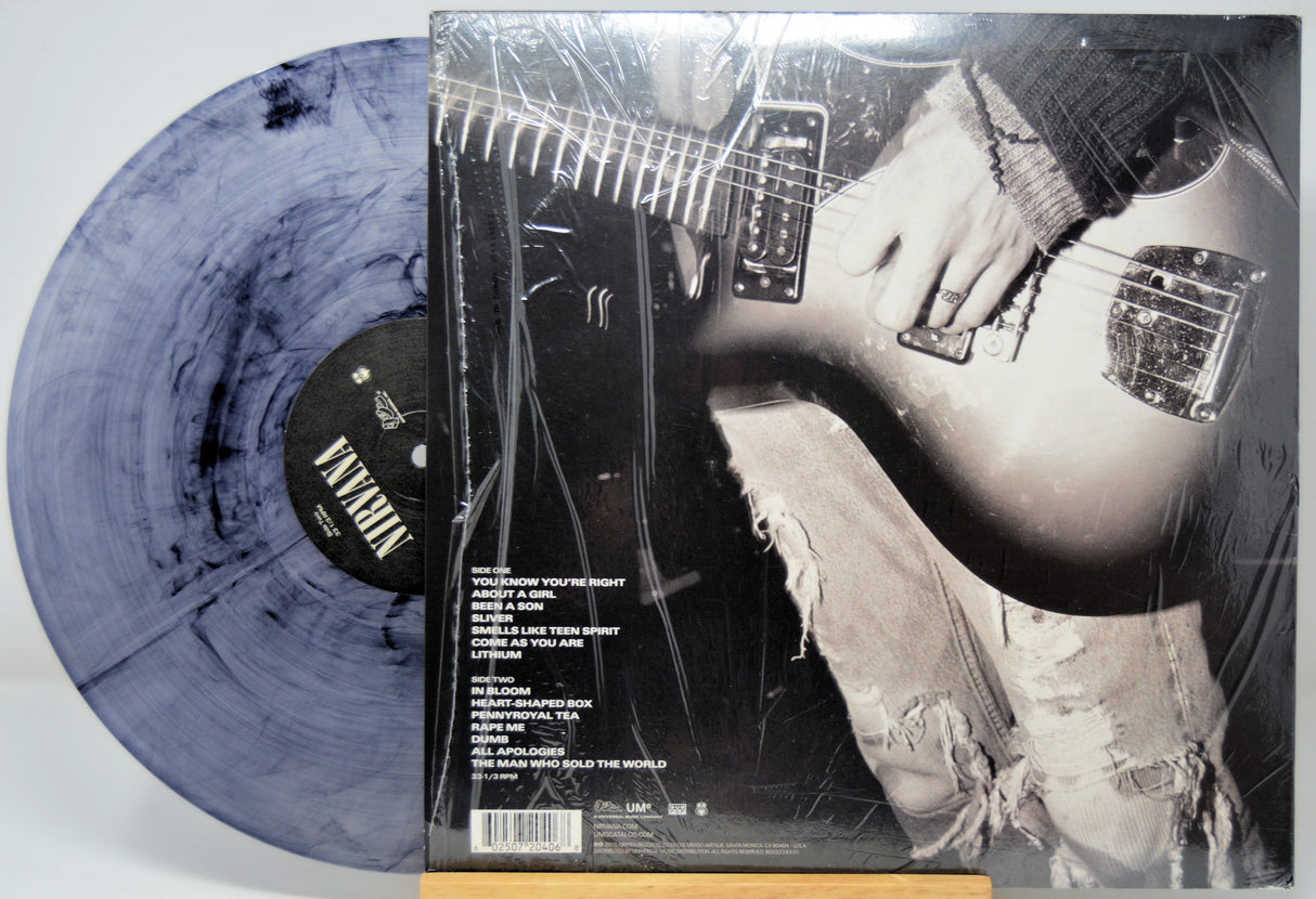 Nirvana selft titled vinyl record with a smoke swirl design and a black and white photo of a person playing guitar on the cover.