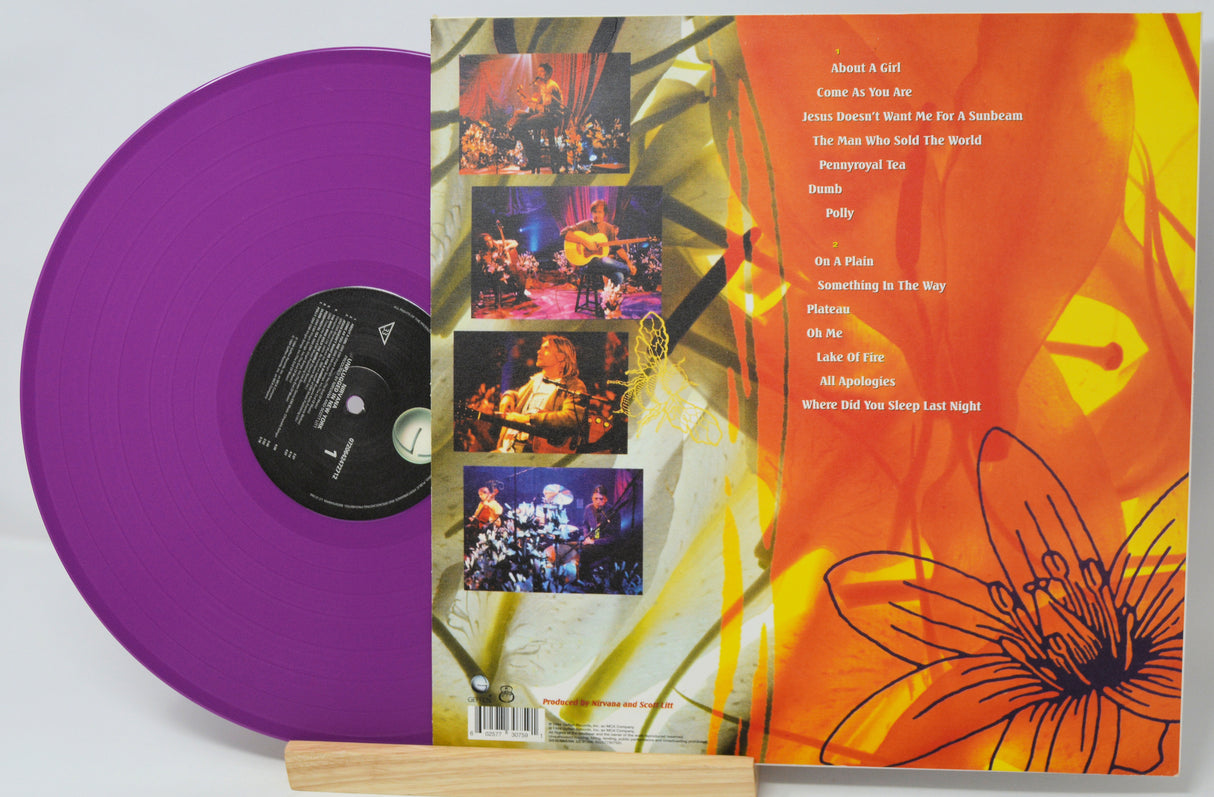 Purple vinyl record with a colorful album cover featuring images and text.