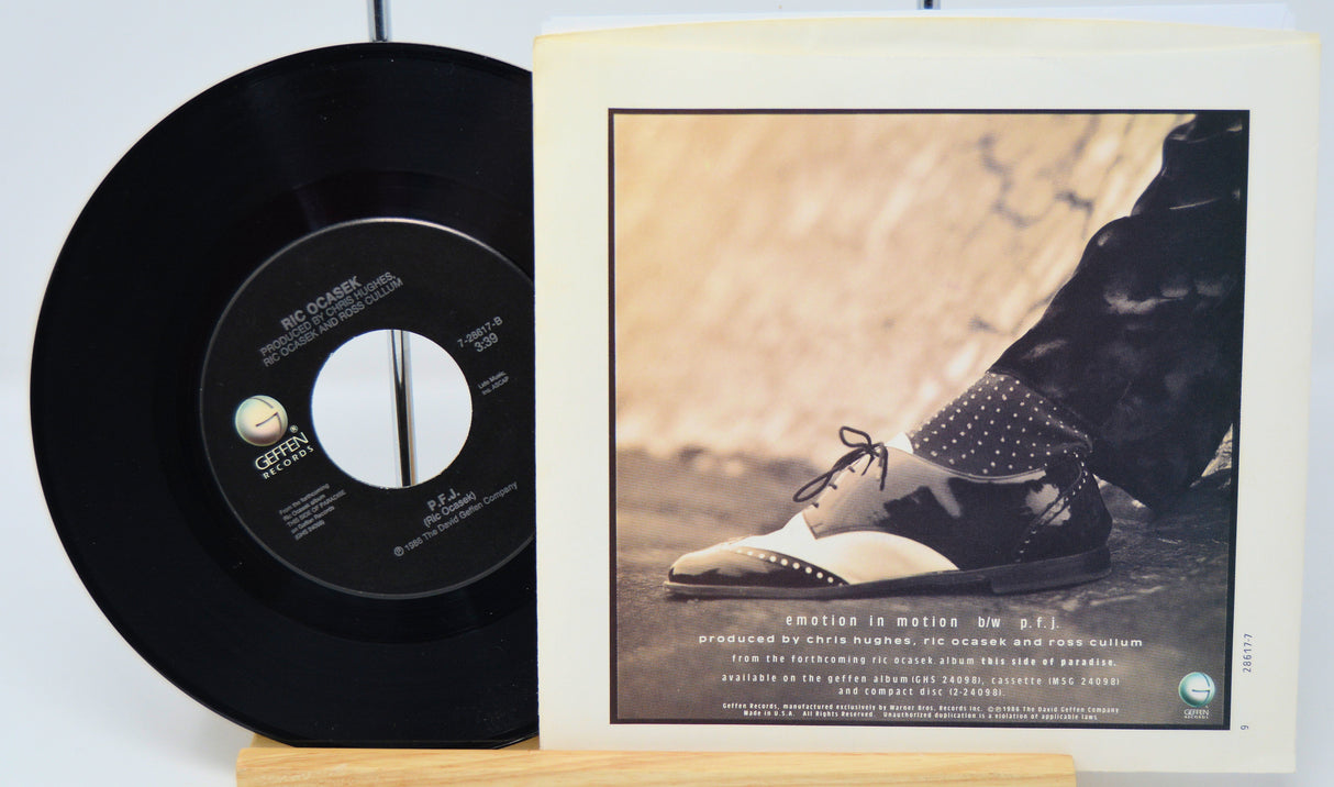 Vinyl record with a cover featuring a person's feet in shoes on a light background